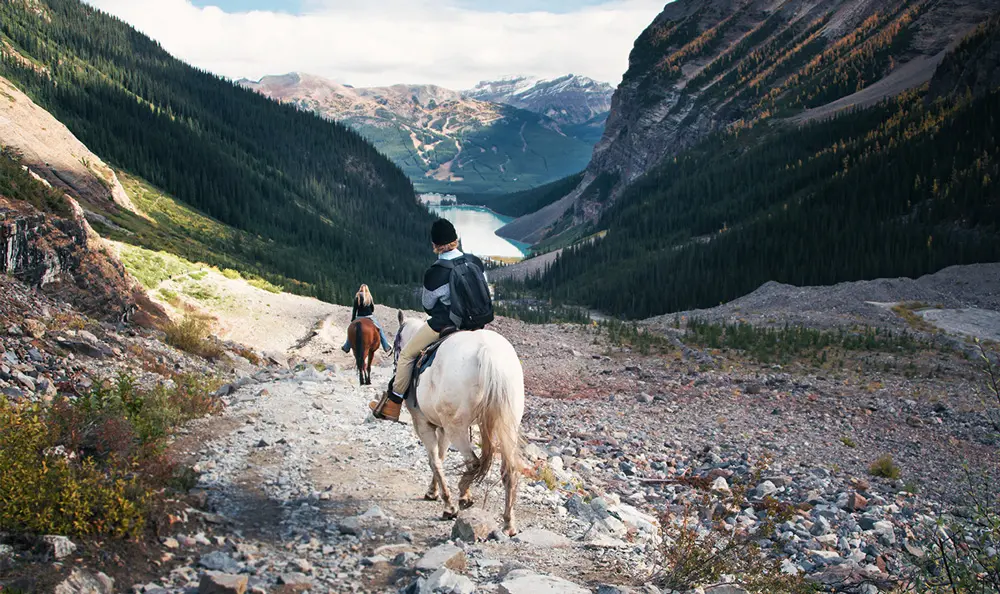 Personnes à cheval dans les montagnes avec vue sur un lac